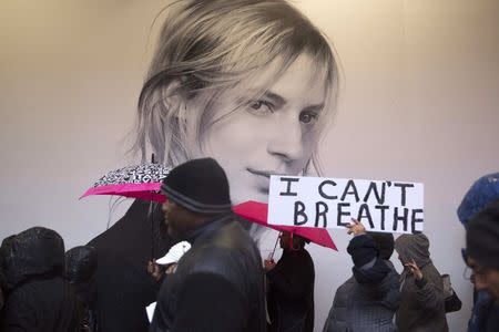 Protesters walk by a billboard during a march for chokehold death victim Eric Garner in New York December 6, 2014. REUTERS/Andrew Kelly