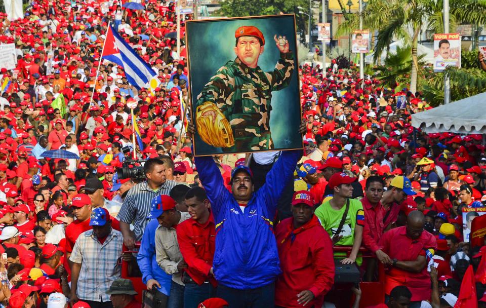 El candidato oficialista a la presidencia de Venezuela, Nicolás Maduro, alza un retrato de Hugo Chávez, este martes en Vargas.