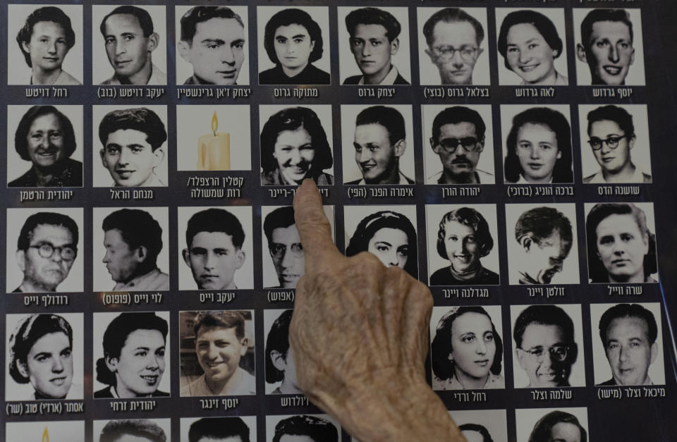 Dezi Heffner-Reiner points to her photo on a poster in memory of members of the Zionist youth movement underground in Hungary during the Holocaust at a ceremony awarding the Jewish Rescuers Citation, at Kibbutz HaZorea, northern Israel, Tuesday, Dec. 13, 2022. Just before Nazi Germany invaded Hungary in March 1944, Jewish youth leaders in the eastern European country jumped into action: they formed an underground network that in the coming months would rescue tens of thousands of fellow Jews from the gas chambers. (AP Photo/Tsafrir Abayov)