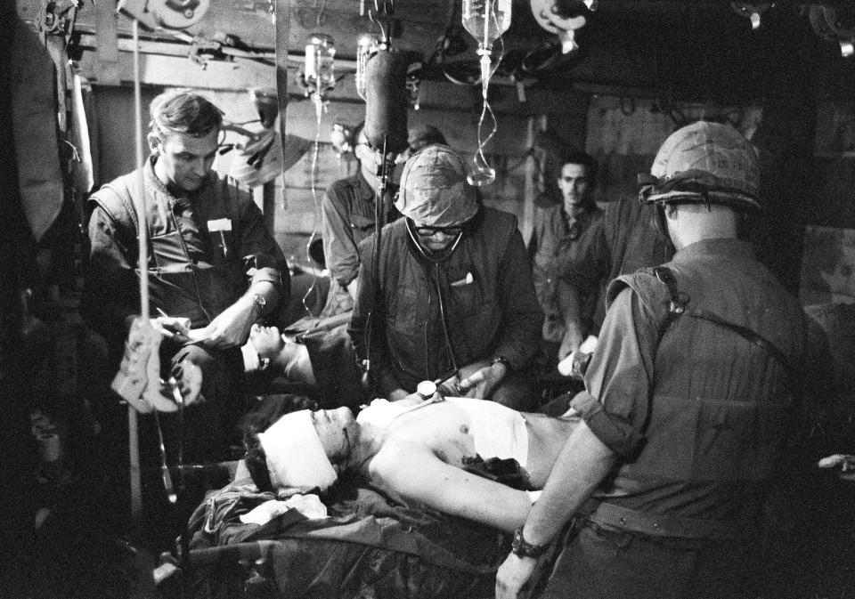 There is little time for cleanliness or relaxation at Charlie Med, the makeshift hospital of Company, 3rd Marine Medical Battalion, handling the wounded at Khe Sanh, Vietnam, March 8, 1968. Doctors, working in the cramped area under continuous battle conditions, make daily life and death decisions in determining the order of who receives treatment for wounds. Using instruments and medicines stored in empty Howitzer cases, Dr. Joseph W. Wolfe, Rutledge, Tenn., center, works on a wounded soldier in the crowded underground hospital bunker at Khe Sanh while Dr. James Finnegan, left, of Philadelphia, and Dr. Edward M. Feldman, Forest Hills, N.Y., back to camera, stand by, all wearing protective flak jackets. (AP Photo/John T. Wheeler)