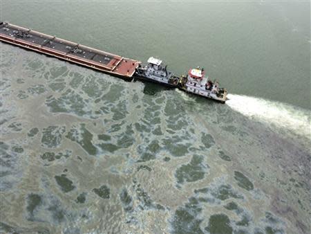 A barge loaded with marine fuel oil sits partially submerged in the Houston Ship Channel in this U.S. Coast Guard picture taken March 22, 2014. REUTERS/US Coast Guard/Handout via Reuters