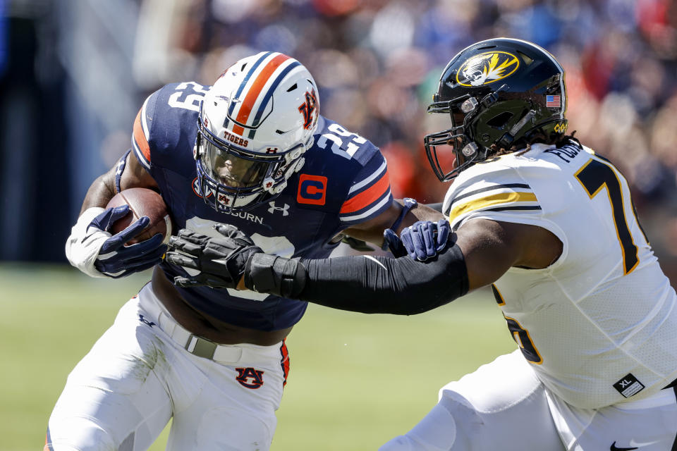 Auburn linebacker Derick Hall (29) carries the ball as Missouri offensive lineman Javon Foster (76) tries to tackle him after an interception during the first half of an NCAA college football game, Saturday, Sept. 24, 2022 in Auburn, Ala. (AP Photo/Butch Dill)