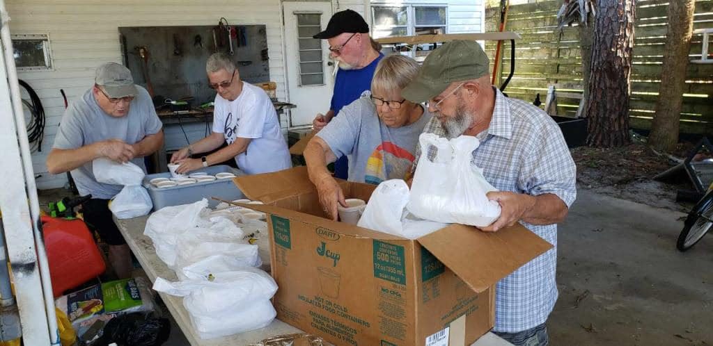 Local volunteers help organize donated meals to be distributed throughout Volusia County neighborhoods in need.