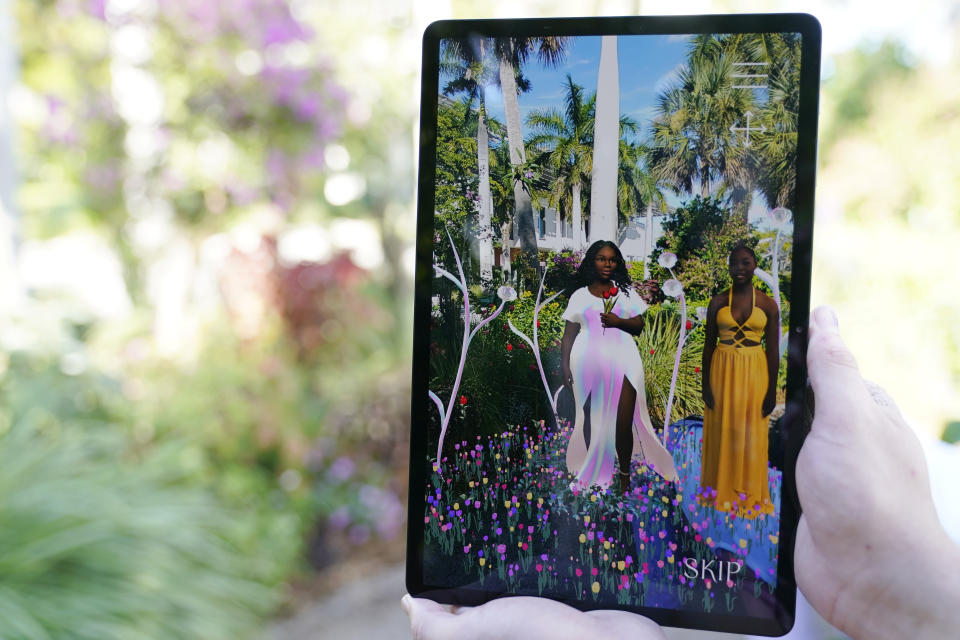 The late Breonna Taylor, left, and her sister Ju'Niyah Palmer, right, are shown on a screen as part of an augmented reality (AR) garden titled "Breonna's Garden" made in her honor at the Maurice A. Ferre Park next to the Perez Art Museum during Miami Art Week, Friday, Dec. 3, 2021, in Miami. Palmer collaborated on the project with artist Lady PheOnix. (AP Photo/Lynne Sladky)