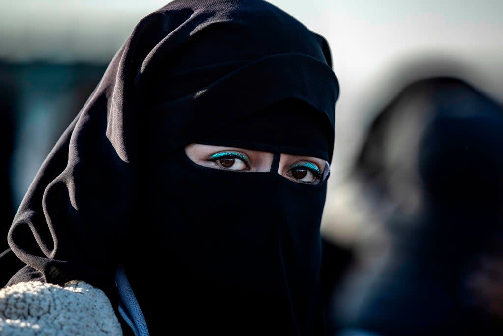 A Syrian woman waits to leave the Kurdish-run al-Hol camp holding relatives of alleged Islamic State group fighter (AFP via Getty Images)