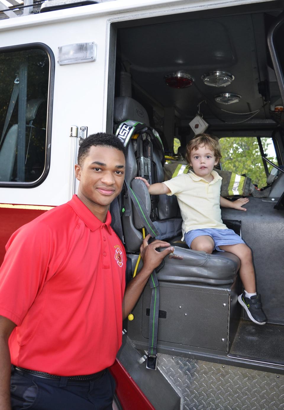 Firefighter Vincent Alexander with Madison Fire Department, Station 3, and Anderson Castle, 2, pose for a photo during Night Out festivities at the Cobblestone subdivision in Madison on Tuesday, Oct. 3.