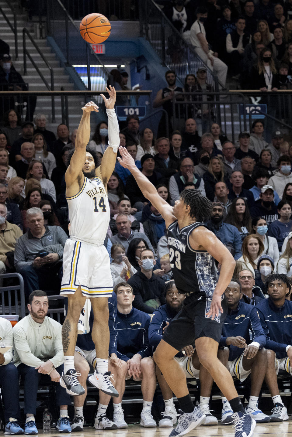 Villanova guard Caleb Daniels (14) takes a three point shot past Georgetown forward Collin Holloway (23) during the second half of an NCAA college basketball game, Saturday, Feb. 19, 2022, in Villanova, Pa. (AP Photo/Laurence Kesterson)