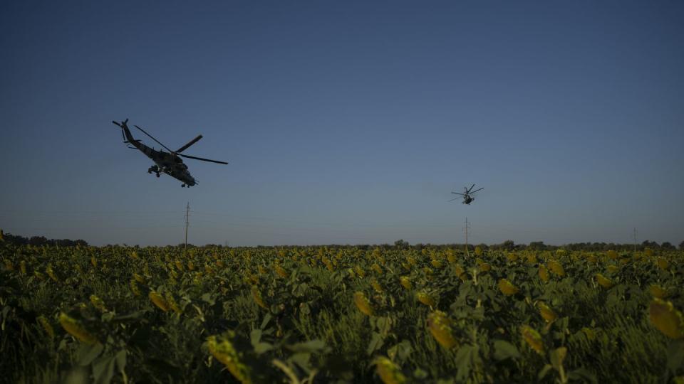 FILE - Ukrainian attack helicopters fly over a sunflower field in eastern Ukraine, Friday, Aug. 18, 2023.  (Bram Janssen/AP)