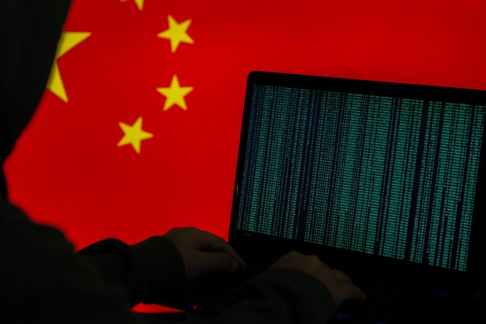 PHOTO: Hacker using a computer with a Chinese flag in the background. (STOCK PHOTO/Getty Images)