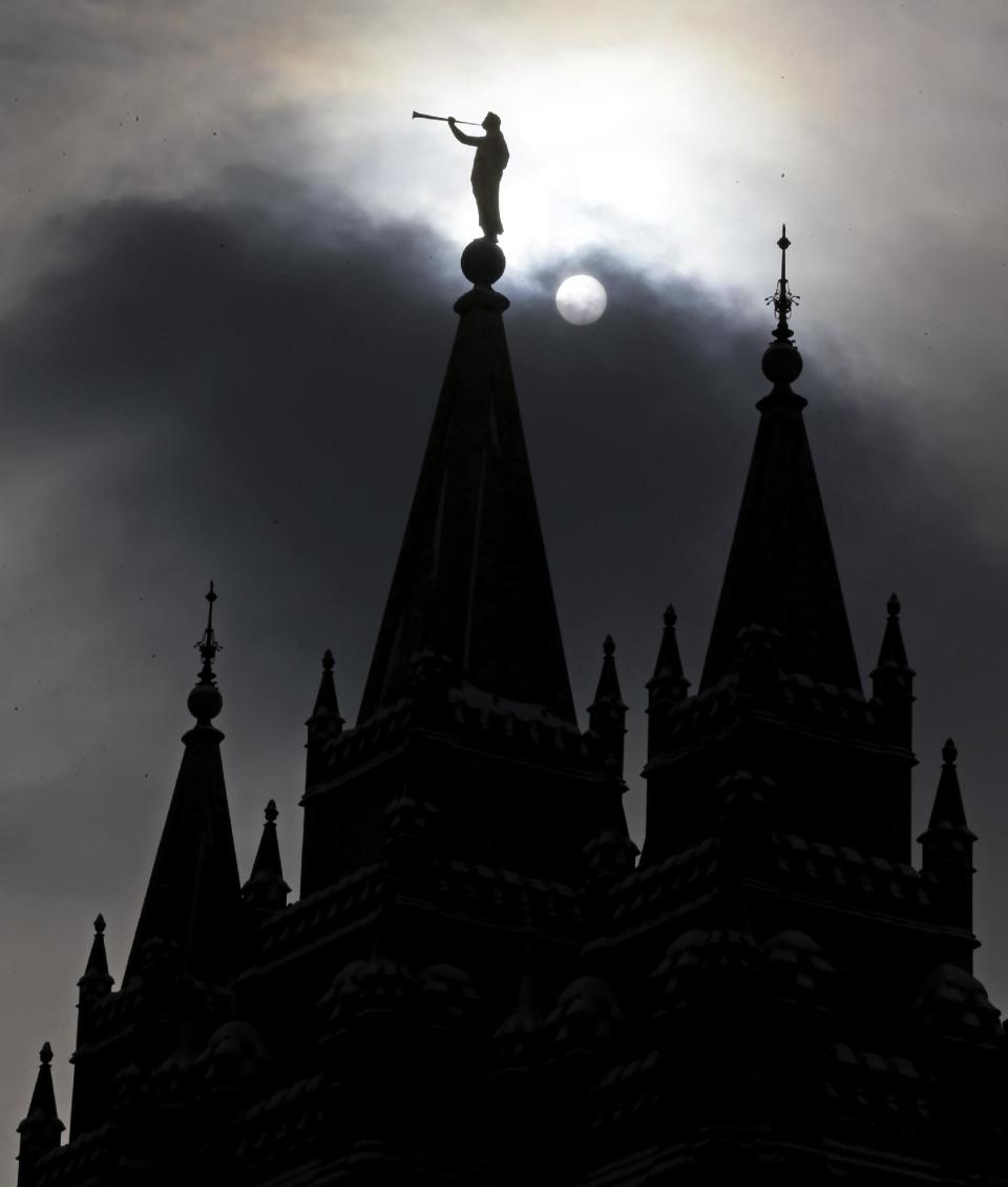 FILE - In this Jan. 29, 2013, file photo, the angel Moroni statue, silhouetted against a cloud-covered sky, sits atop the Salt Lake Temple in Temple Square in Salt Lake City. A newly-posted article, part of a series of recent online articles posted on the website of The Church of Jesus Christ of Latter-day Saints, affirms the faith's belief that humans can become like God in eternity, but explains that the "cartoonish image of people receiving their own planets" is not how the religion envisions it. (AP Photo/Rick Bowmer, File)