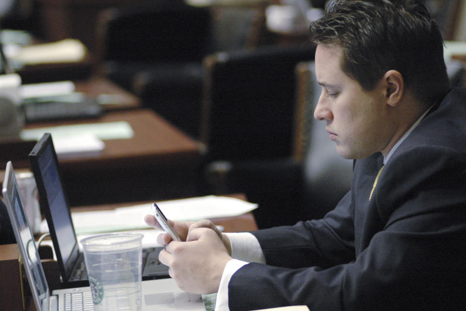 FILE - In this April 9, 2009 file photo, Rep. Ryan Silvey, R-Kansas City, checks his wireless device during House debate, in Jefferson City, Mo. A federal indictment alleges a Missouri nonprofit illegally funneled money to Missouri politicians. Former Republican Sens. Ryan Silvey and Bob Dixon and former Rep. Ward Franz confirmed to The Associated Press they had participated in fundraisers involving officials from Springfield-based Alternative Opportunities Inc. But they said they were unaware that charity resources may have been used for their campaigns. The indictment did not accuse the lawmakers of wrongdoing. (AP Photo/Kelley McCall File)