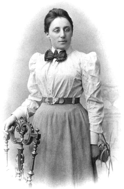 Black and white portrait of young Emmy Noether wearing a shirt and skirt.