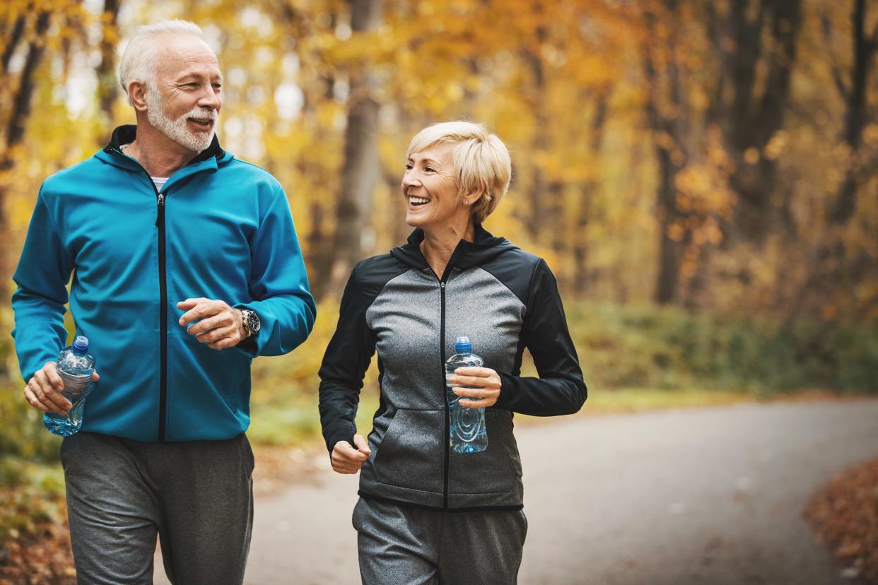 senior couple jogging in a forest