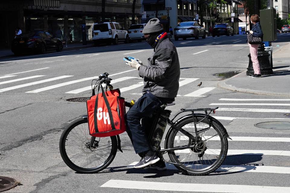 NEW YORK, NY - MAY 03: A Grubhub delivery person checks his phone during the coronavirus pandemic on May 3, 2020 in New York City. COVID-19 has spread to most countries around the world, claiming over 247,000 lives with over 3.5 million infections reported. (Photo by Cindy Ord/Getty Images)