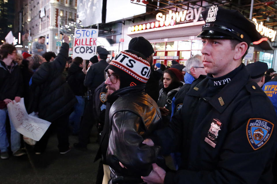 Police make arrests after protesters rallying against a grand jury's decision not to indict the police officer involved in the death of Eric Garner attempted to block traffic at the intersection of 42nd Street and Seventh Avenue near Times Square, Thursday, Dec. 4, 2014, in New York. (AP Photo/Jason DeCrow)