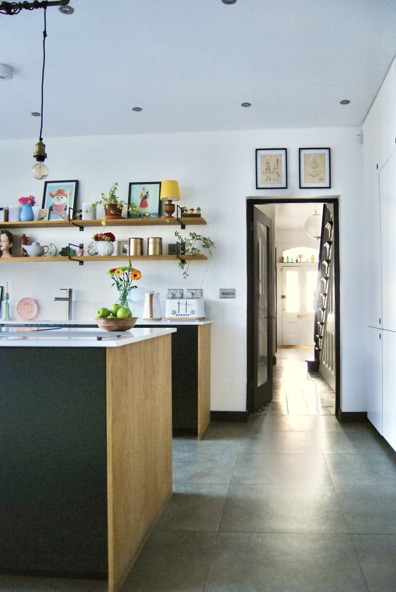 Kitchen with white counter tops black cabinets and wooden accents.