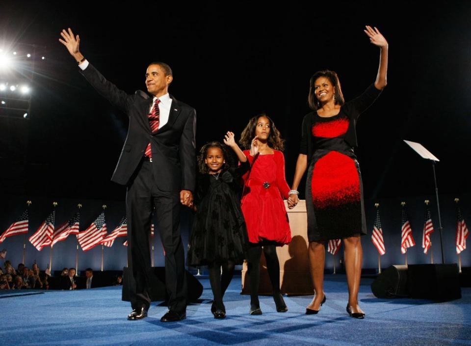 U.S. President elect Barack Obama stands on stage along with his wife Michelle and daughters Malia (red dress) and Sasha (black dress) during an election night gathering in Grant Park on November 4, 2008 in Chicago, Illinois. Obama defeated Republican nominee Sen. John McCain (R-AZ) by a wide margin in the election to become the first African-American U.S. President elect. (Photo by Joe Raedle/Getty Images)