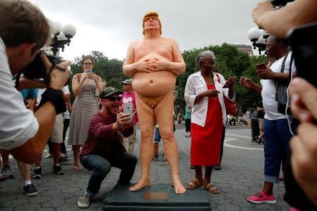 People photograph and pose for selfies with a naked statue of U.S. Republican presidential nominee Donald Trump that was left in Union Square Park in New York City, U.S. August 18, 2016. REUTERS/Brendan McDermid