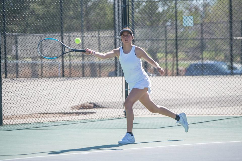 Pueblo East's Ava Andrada strtches out for a return during a match at Pueblo City Park on Tuesday, April 11, 2023.