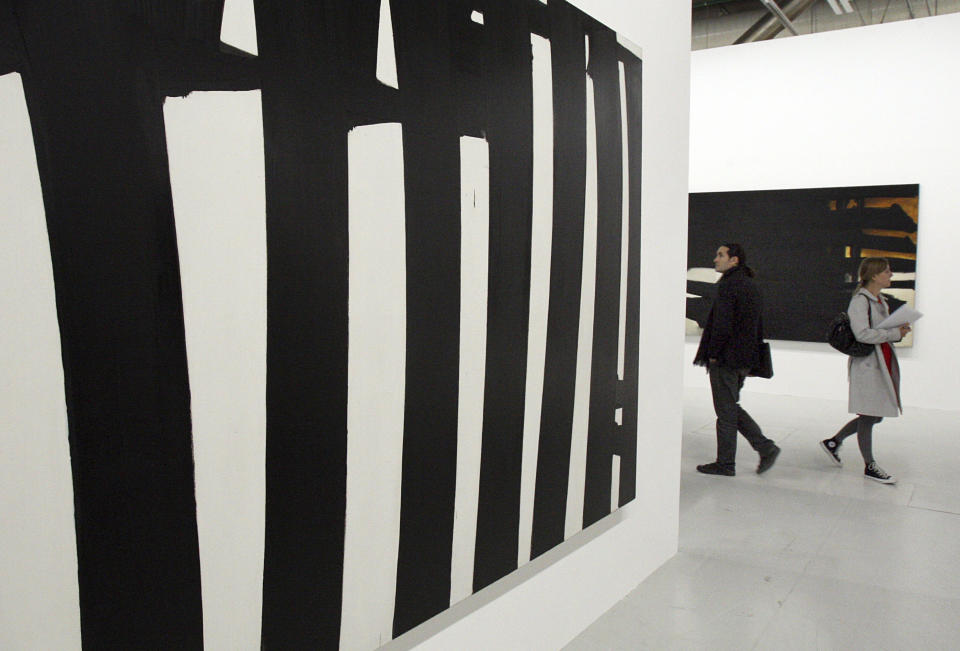 FILE - Journalists visit and exhibition of French painter Pierre Soulages at the Pompidou art Center in Paris, Tuesday Oct. 13, 2009. French painter Pierre Soulages, who was famed for his use of black and was an icon of post-World War II European abstract art, has died, according to the Soulages Museum in his hometown. He was 102. (AP Photo/Remy de la Mauviniere, File)