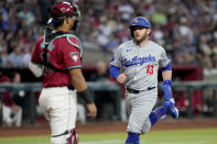 Los Angeles Dodgers' Max Muncy (13) scores on a sacrifice fly hit by Andy Pages during the second inning of a baseball game against the Arizona Diamondbacks, Monday, April 29, 2024, in Phoenix. (AP Photo/Matt York)
