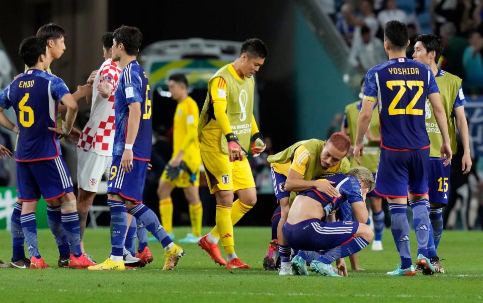 Japan players are dejected after Croatia's win in the World Cup round of 16 soccer match between Japan and Croatia at the Al Janoub Stadium in Al Wakrah, Qatar - Japan World Cup 2022 results, squad list, fixtures and latest odds - Eugene Hoshiko/AP