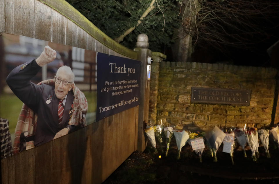 Flowers are placed near the home of Captain Tom Moore in Marston Moretaine, England, Tuesday, Feb. 2, 2021. Tom Moore, the 100-year-old World War II veteran who captivated the British public in the early days of the coronavirus pandemic with his fundraising efforts, has died, Tuesday Feb. 2, 2021. (AP Photo/Kirsty Wigglesworth)