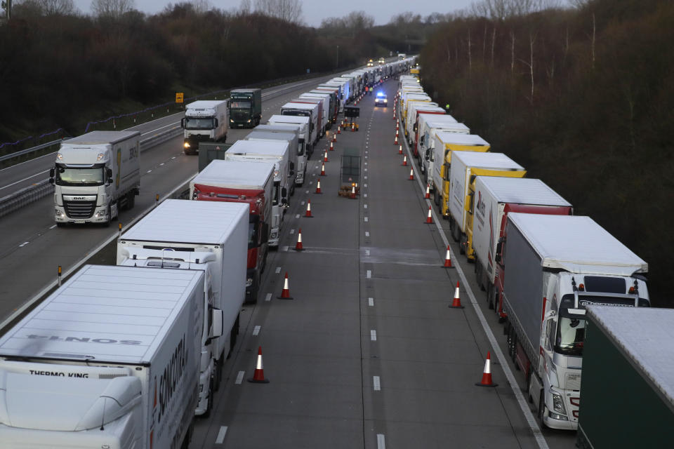 Trucks are parked up on the M20, as more arrive to join the queue, part of Operation Stack in Ashford, Kent, England, Friday, Dec. 25, 2020. Thousands wait to resume their journey across The Channel after the borders with France reopened. Trucks inched slowly past checkpoints in Dover and headed across the Channel to Calais on Thursday after France partially reopened its borders following a scare over a rapidly spreading new virus variant. (AP Photo/Kirsty Wigglesworth)