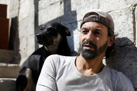 Abu Nimr, 36, is pictured with his dog in Yarmouk Palestinian camp in Damascus, Syria October 10, 2018. Picture taken October 10, 2018. REUTERS/Omar Sanadiki