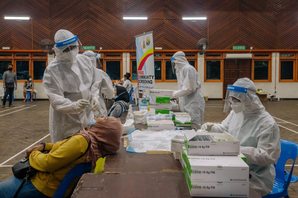 Healthcare workers in protective suits are seen conducting Covid-19 testing in Ampang May 18, 2021. — Picture by Firdaus Latif