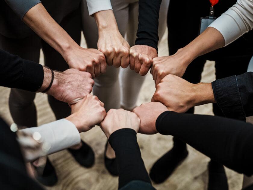 Ukrainian cast members put their fists together in a circle to form a crown.