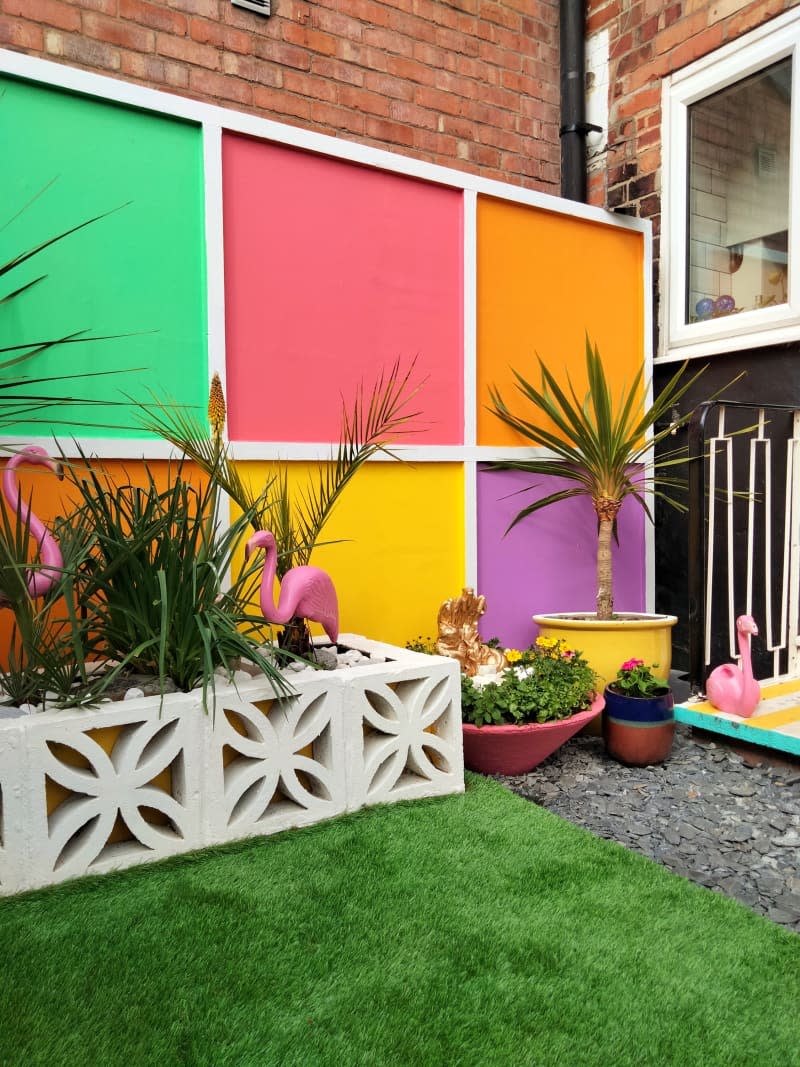 Flamingos and multi-colored tiles in an outdoor space.