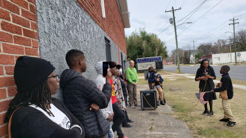 Apostle Cordelia Challenger of Greater Unity Tabernacle Christian Church helps a young person participate in a prayer service on Dec. 3, 2023. The downtown church has held a prayer service every Sunday at 2 p.m. since it was vandalized in November with hateful graffiti.