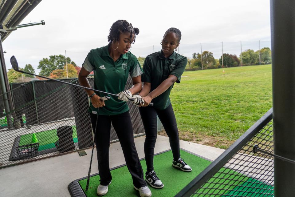 Cass Tech varsity golf player Sydney Evans, left, goes over a swing with teammate Nyla Joseph at the Royal Oak Golf Center in Royal Oak on Tuesday, October 17, 2023, before their Division 1 State Championship Tournament this weekend. Cass Tech is the first girl's team from Detroit to reach that level and the team is only three years old.