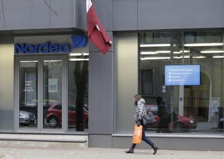 A woman walks past Nordea bank Latvia's branch headquarters in Riga October 22, 2014. REUTERS/Ints Kalnins