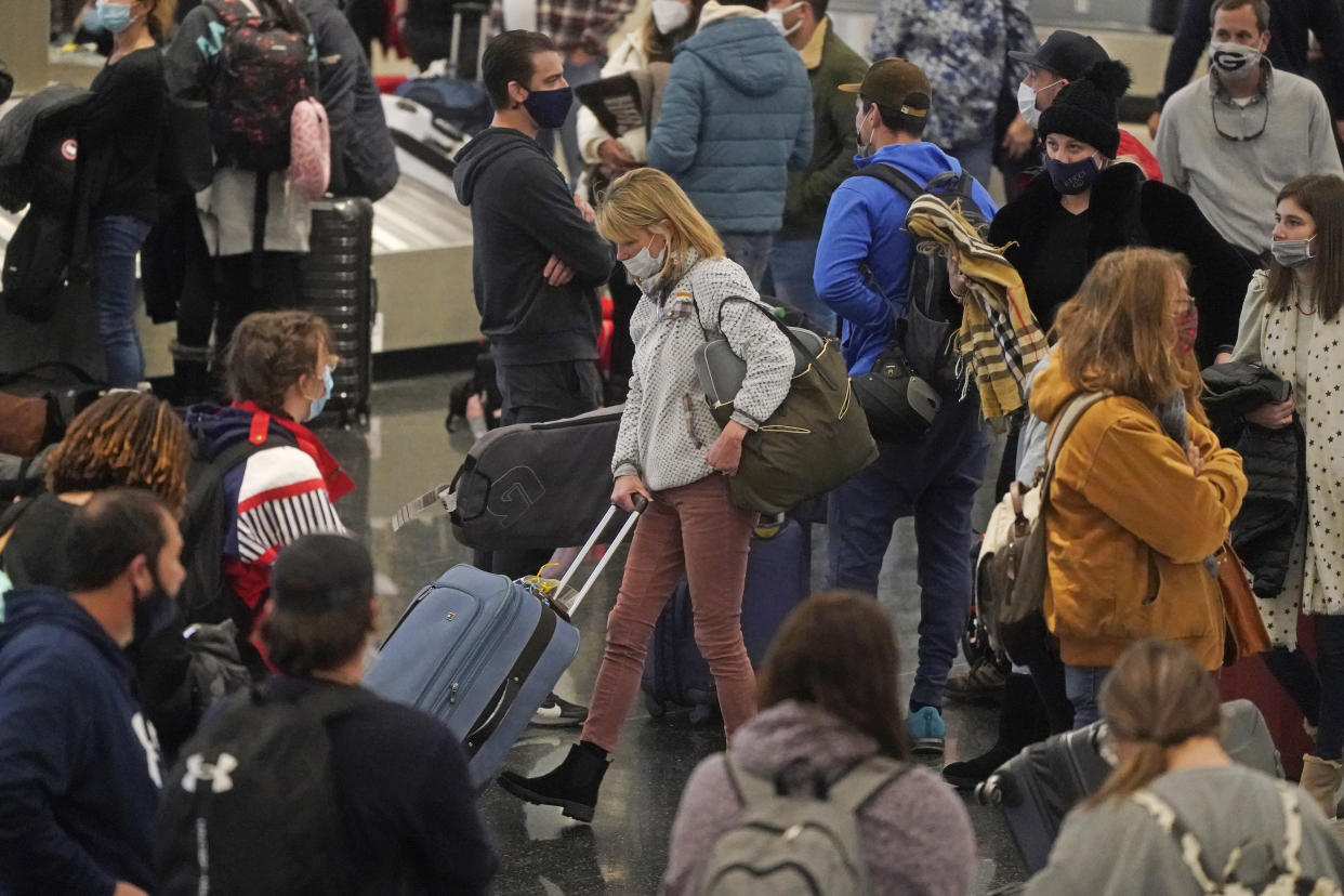 Travelers pass through Salt Lake City International Airport Wednesday, Jan. 5, 2022, in Salt Lake City. (AP Photo/Rick Bowmer)