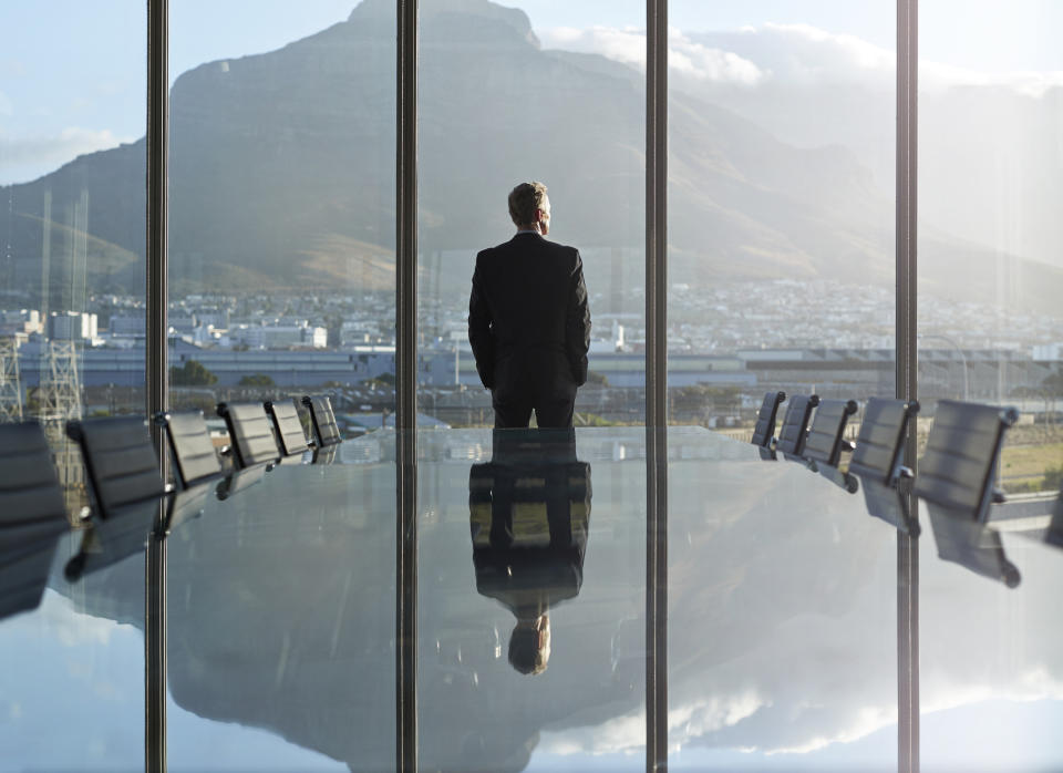 man in a conference room looking out at the city view