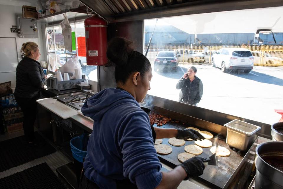 Cook Veronica Campos prepares tacos on the Los Karnales food truck at La Placita food truck park on 9th Street in Modesto, Calif., Tuesday, Dec. 13, 2022.