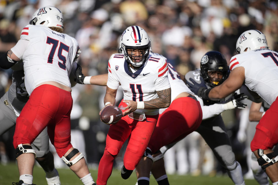 Arizona quarterback Noah Fifita (11) hands off the ball in the second half of an NCAA college football game against Colorado on Saturday, Nov. 11, 2023, in Boulder, Colo. (AP Photo/David Zalubowski)