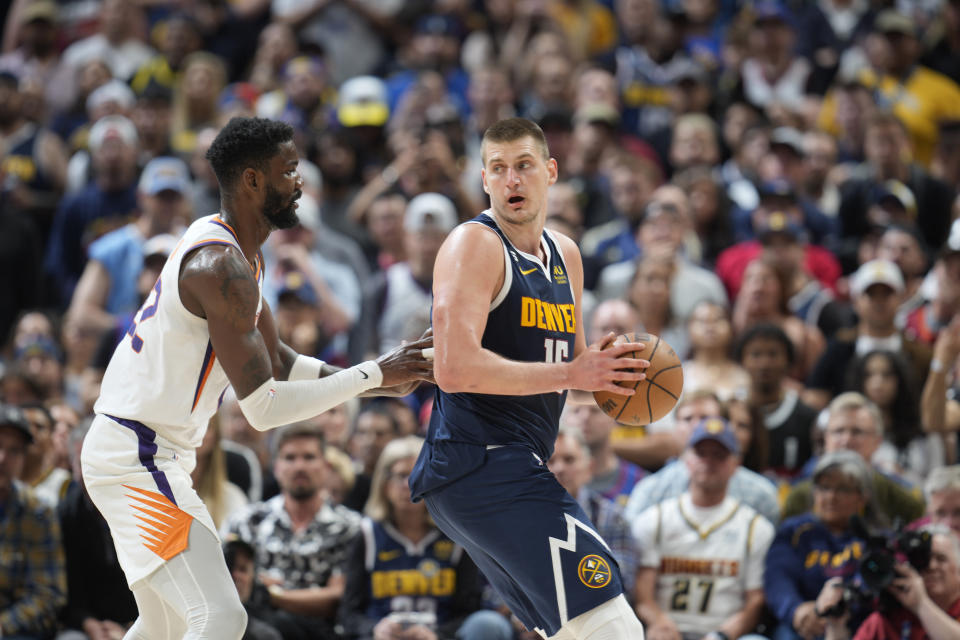 Denver Nuggets center Nikola Jokic (15) and Phoenix Suns center Deandre Ayton (22) in the second half of Game 2 of an NBA second-round playoff series Monday, May 1, 2023, in Denver. (AP Photo/David Zalubowski)