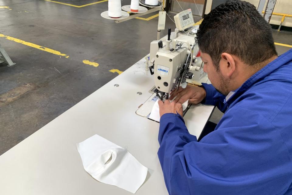 A Citizens of Humanity employee work to produce face masks at the brand's headquarters in Huntington Park.