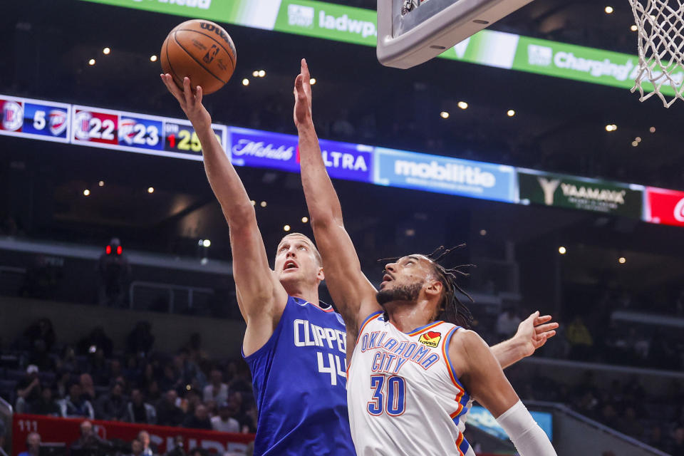 Los Angeles Clippers forward Mason Plemlee, left, and Oklahoma City Thunder forward Olivier Sarr reach for a rebound during the first half of an NBA basketball game Tuesday, March 21, 2023, in Los Angeles. (AP Photo/Ringo H.W. Chiu)