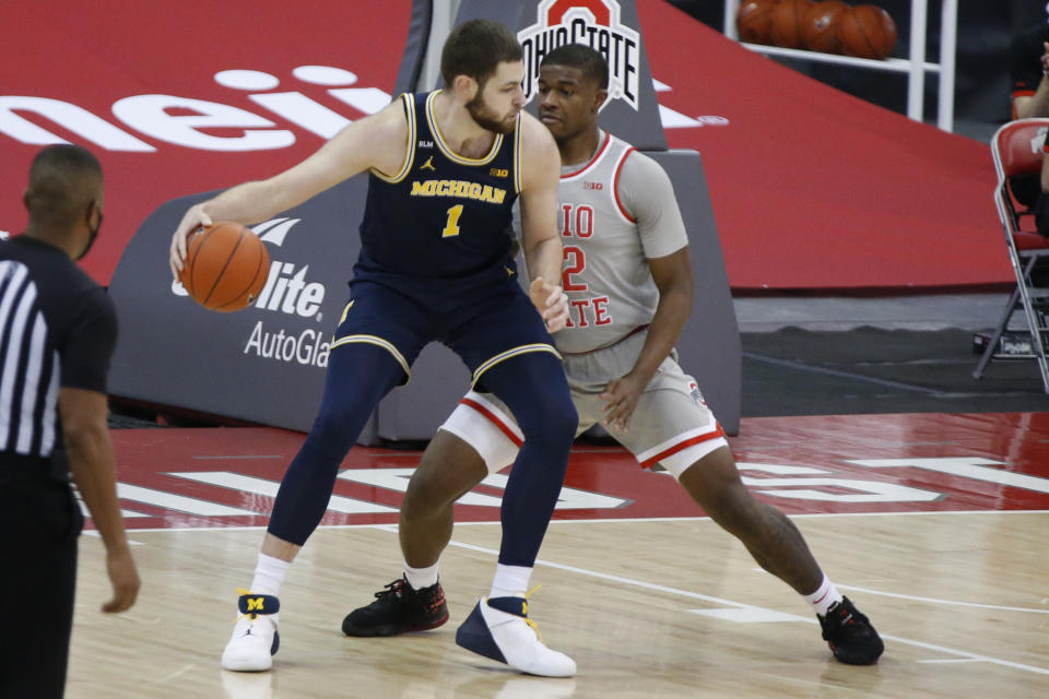 Michigan's Hunter Dickinson, left, posts up against Ohio State's E.J. Liddell during the first half of an NCAA college basketball game Sunday, Feb. 21, 2021, in Columbus, Ohio. (AP Photo/Jay LaPrete)