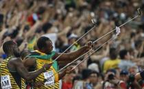 Nickel Ashmeade and Usain Bolt of Jamaica make selfies after winning the men's 4x100m relay during the 15th IAAF World Championships at the National Stadium in Beijing, China August 29, 2015. REUTERS/Lucy Nicholson