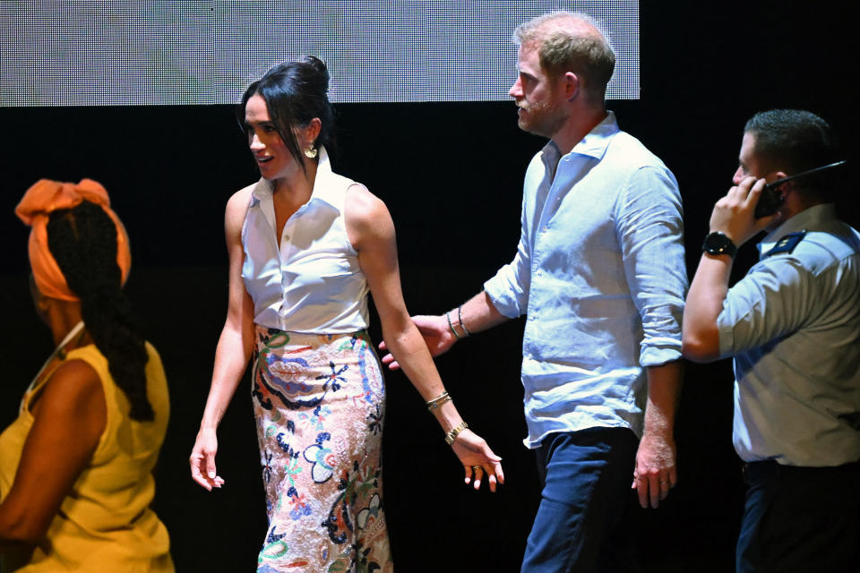 Britain's Prince Harry (2nd R), Duke of Sussex, and his wife Meghan Markle walk onto the stage for a family photo at the end of the 