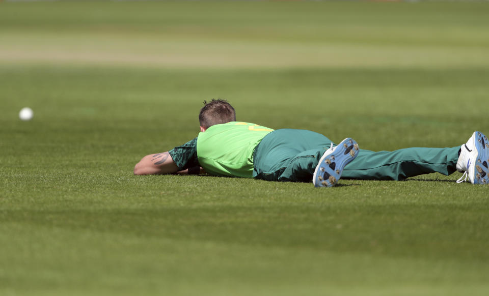 South Africa's bowler Chris Morris lies on the ground to avoid a swarm of bees that have come across the ground during the Cricket World Cup match between Sri Lanka and South Africa at the Riverside Ground in Chester-le-Street, England, Friday, June 28, 2019. (AP Photo/Scott Heppell)