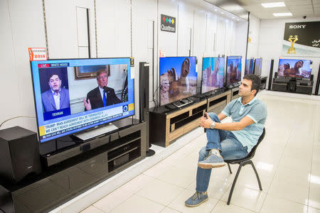 FILE PHOTO: A man watches a television broadcast of U.S. President Donald Trump's speech, in Tehran, Iran October 13, 2017. Nazanin Tabatabaee Yazdi/TIMA/File Photo via REUTERS