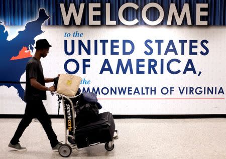 A man exits the transit area after clearing immigration and customs on arrival at Dulles International Airport in Dulles, Virginia, U.S., September 24, 2017. REUTERS/James Lawler Duggan/Files