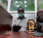 Abolaji Odunjo, a gadget vendor who trades with bitcoin, poses with his mobile phone after an interview with Reuters at his store at the '"Computer village", in Lagos