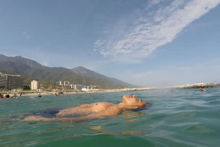 Victor floats in the sea as he spends a day at Coral beach, La Guaira, near Caracas, Venezuela, March 23, 2019. REUTERS/Ivan Alvarado